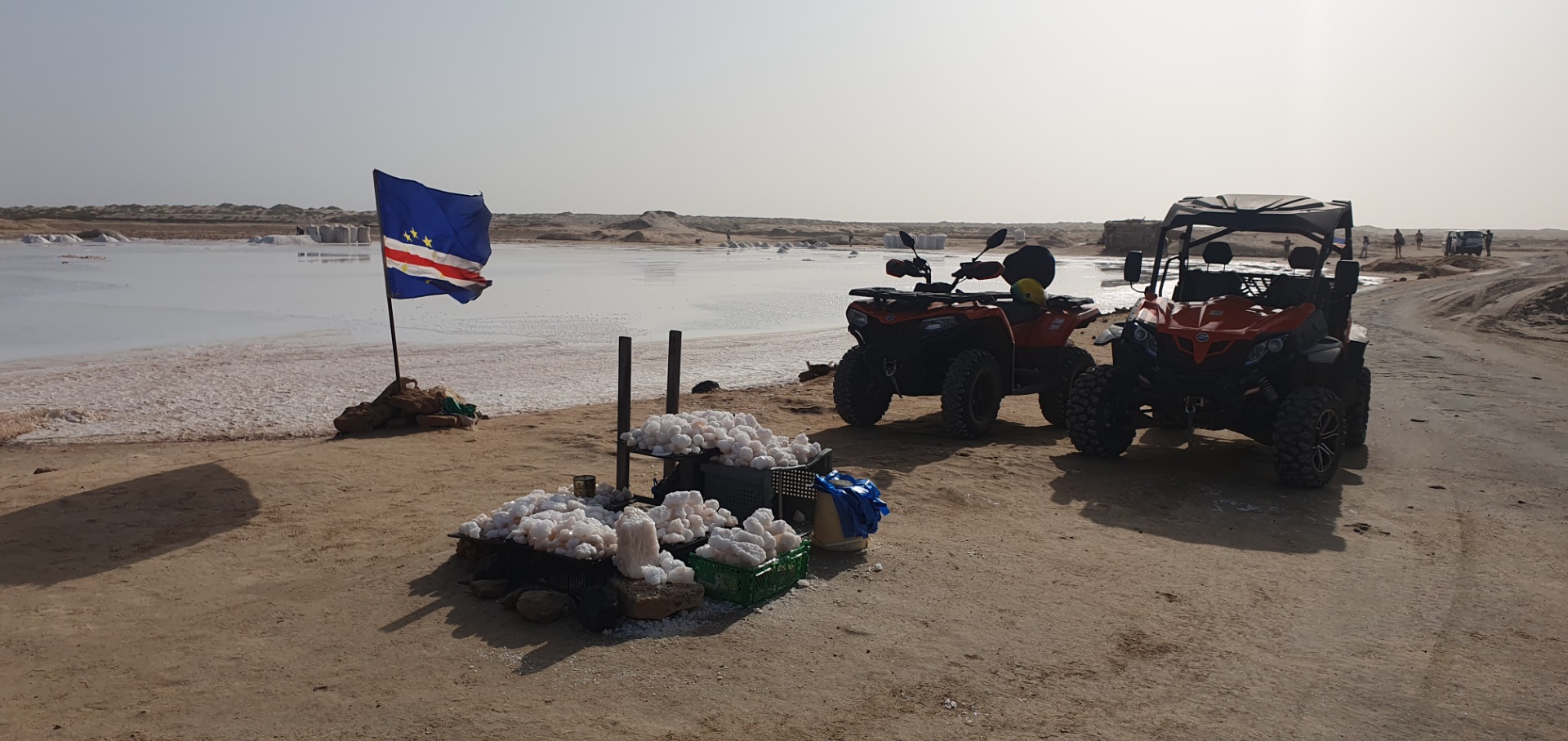 Sal - Cabo Verde - Rotes Geländefahrzeug mit Anhänger am Strand, EU-Flagge, Kisten mit Eiern und Quads im Hintergrund.