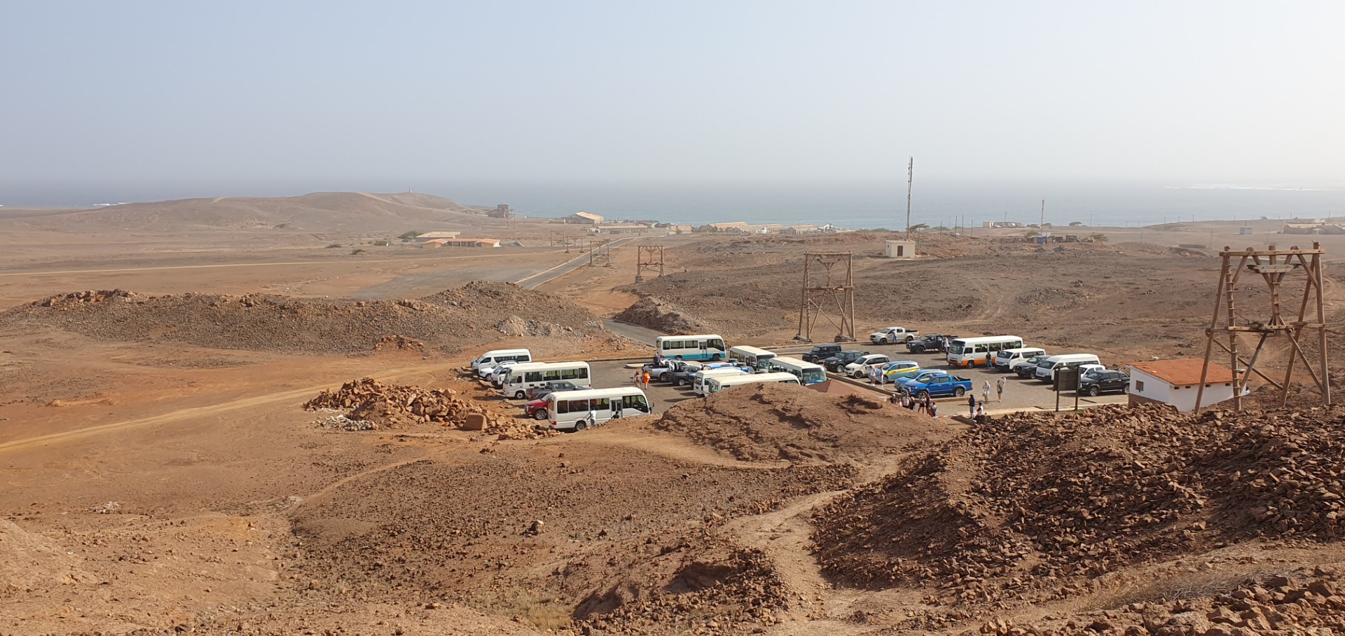 Pedra de Lume - Sal - Konvoi von Reisebussen und Autos steht auf staubiger Straße in einer trockenen Wüstenlandschaft.
